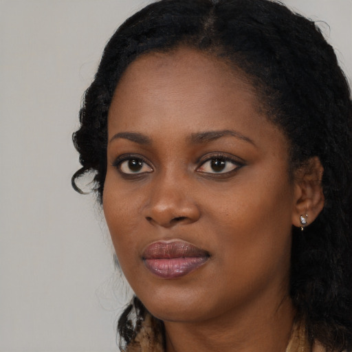 Joyful black young-adult female with long  black hair and brown eyes