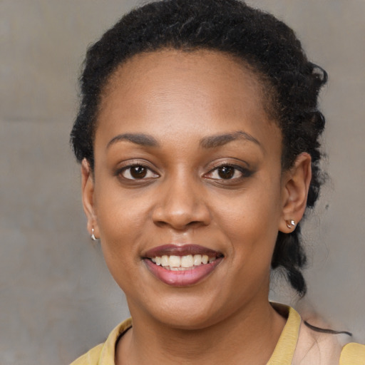 Joyful black young-adult female with short  black hair and brown eyes