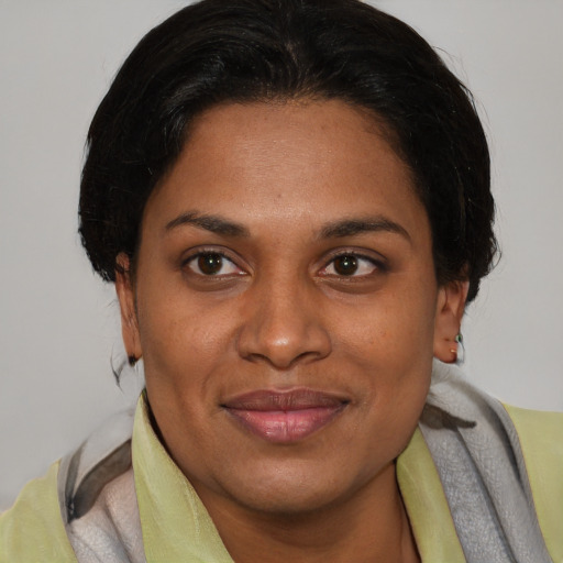 Joyful latino adult female with short  brown hair and brown eyes