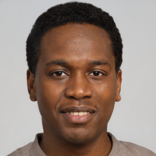 Joyful black young-adult male with short  black hair and brown eyes