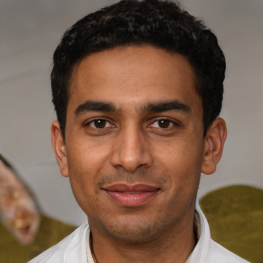 Joyful latino young-adult male with short  black hair and brown eyes
