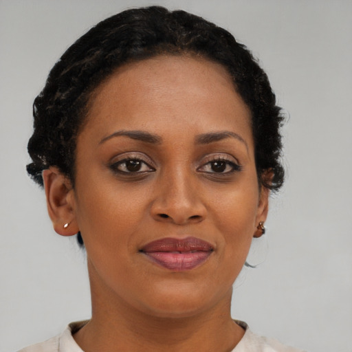 Joyful black young-adult female with short  brown hair and brown eyes