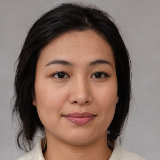 Joyful asian young-adult female with medium  brown hair and brown eyes