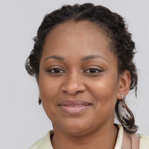 Joyful black young-adult female with medium  brown hair and brown eyes