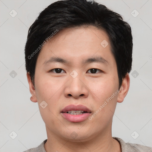 Joyful asian young-adult male with short  black hair and brown eyes
