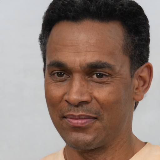 Joyful black adult male with short  black hair and brown eyes