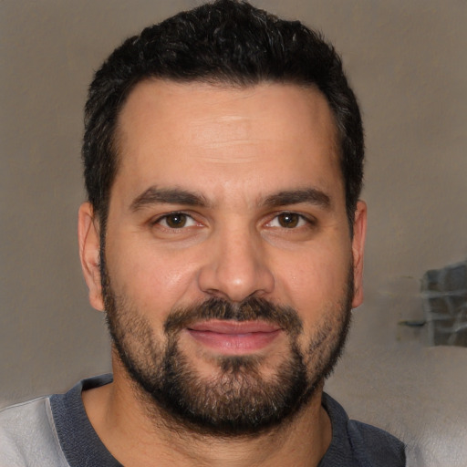 Joyful white young-adult male with short  black hair and brown eyes