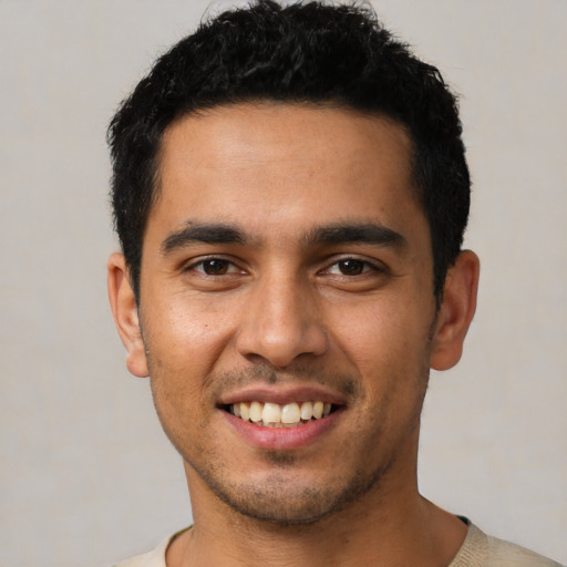Joyful latino young-adult male with short  black hair and brown eyes