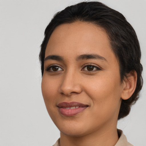 Joyful latino young-adult female with short  black hair and brown eyes