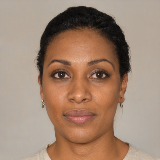 Joyful black young-adult female with short  black hair and brown eyes