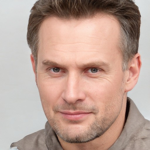 Joyful white adult male with short  brown hair and grey eyes