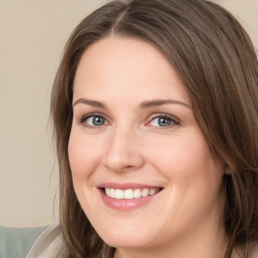 Joyful white young-adult female with long  brown hair and brown eyes