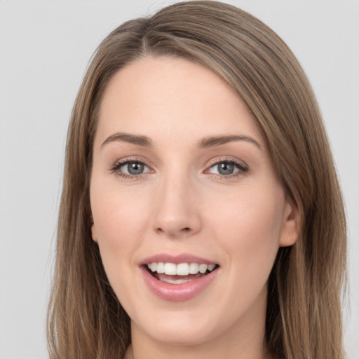 Joyful white young-adult female with long  brown hair and grey eyes