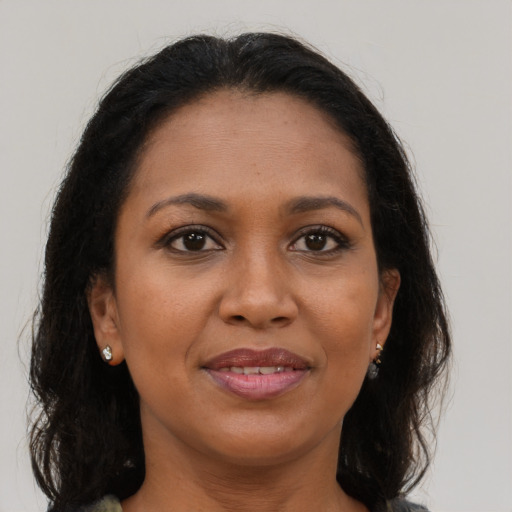 Joyful black adult female with long  brown hair and brown eyes