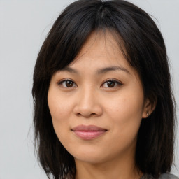 Joyful asian young-adult female with long  brown hair and brown eyes