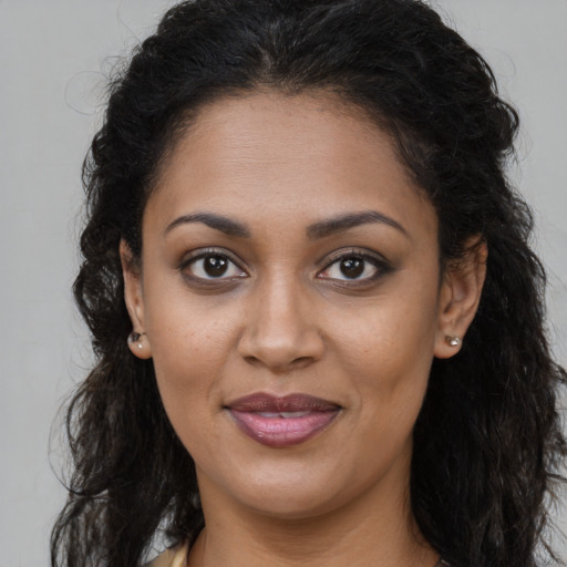 Joyful black young-adult female with long  brown hair and brown eyes