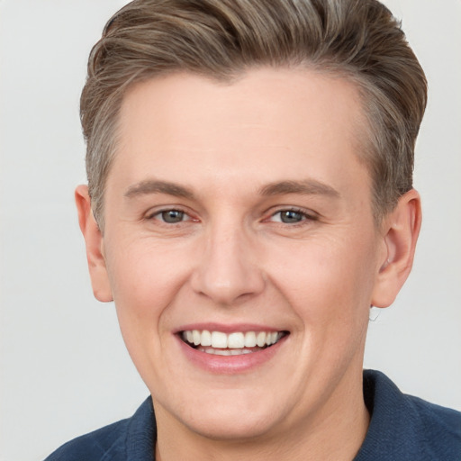 Joyful white young-adult male with short  brown hair and grey eyes