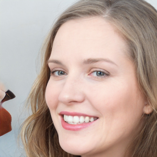 Joyful white young-adult female with long  brown hair and blue eyes