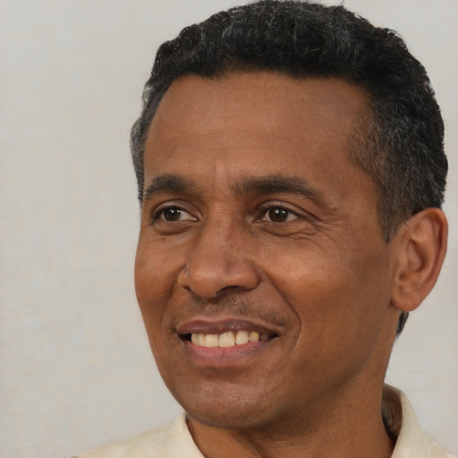 Joyful black adult male with short  black hair and brown eyes