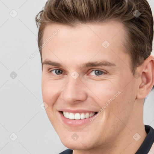 Joyful white young-adult male with short  brown hair and grey eyes