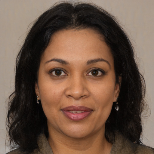 Joyful black adult female with medium  brown hair and brown eyes