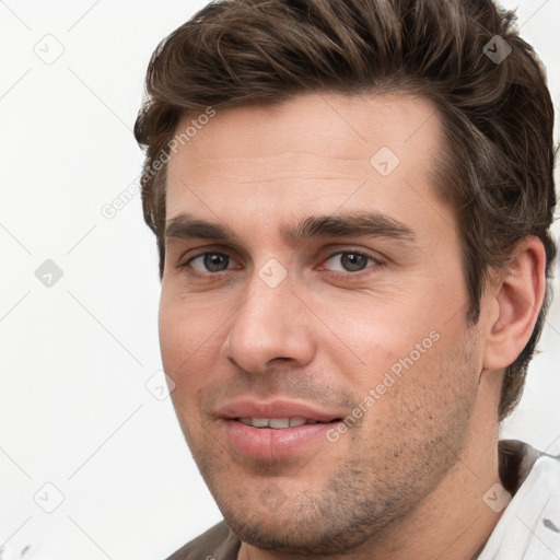 Joyful white young-adult male with short  brown hair and grey eyes