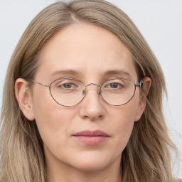 Joyful white adult female with long  brown hair and blue eyes