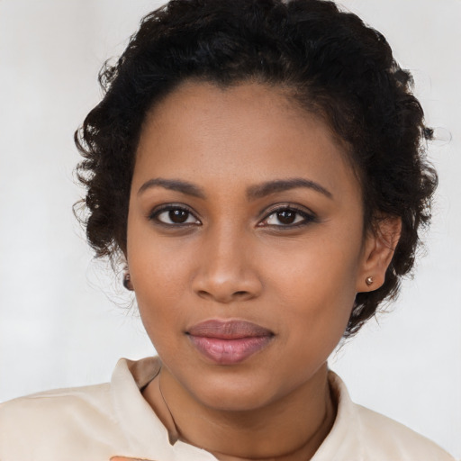 Joyful black young-adult female with long  brown hair and brown eyes