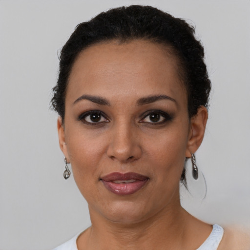 Joyful black adult female with short  black hair and brown eyes