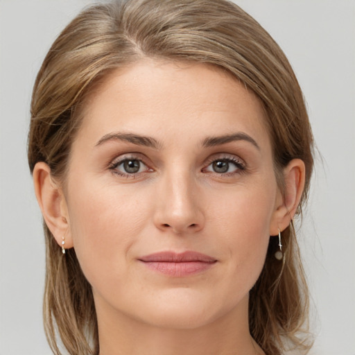 Joyful white young-adult female with medium  brown hair and grey eyes