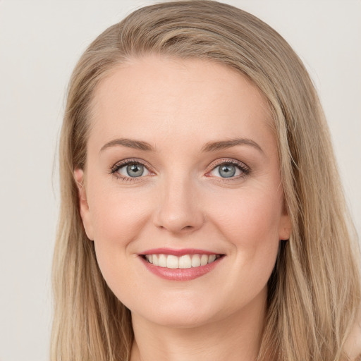 Joyful white young-adult female with long  brown hair and blue eyes