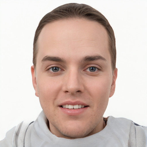 Joyful white young-adult male with short  brown hair and grey eyes