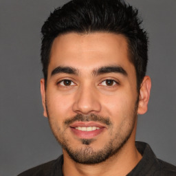 Joyful latino young-adult male with short  black hair and brown eyes