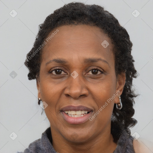 Joyful black adult female with long  brown hair and brown eyes