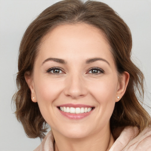 Joyful white young-adult female with medium  brown hair and grey eyes