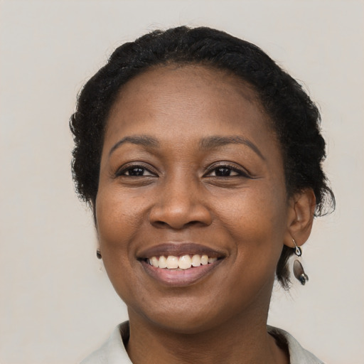 Joyful black adult female with short  black hair and brown eyes