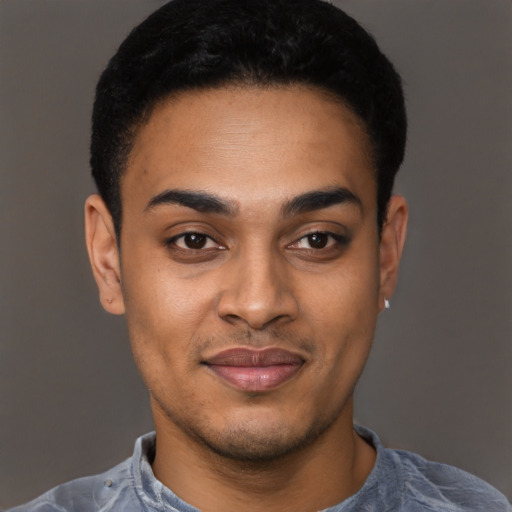 Joyful black young-adult male with short  black hair and brown eyes