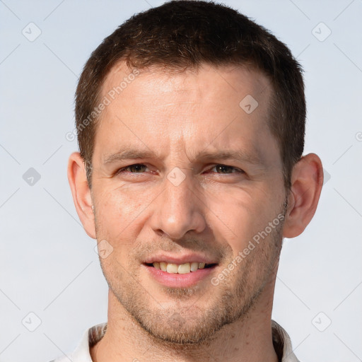 Joyful white adult male with short  brown hair and brown eyes