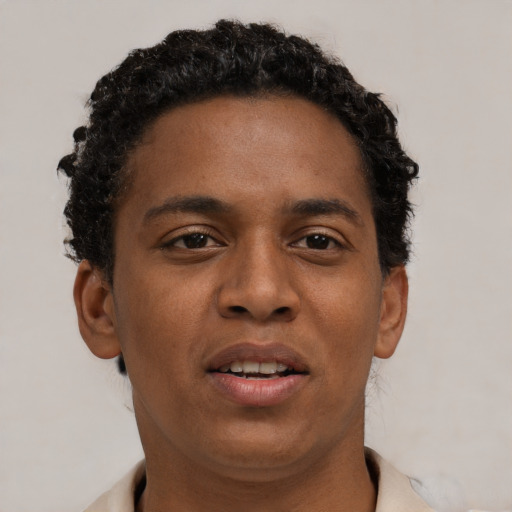 Joyful black young-adult male with short  brown hair and brown eyes