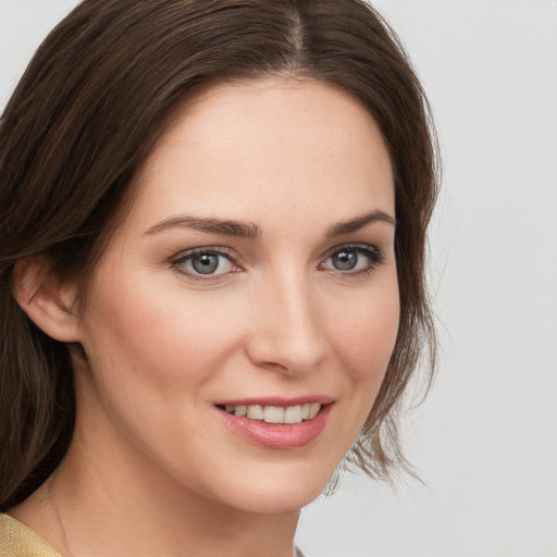 Joyful white young-adult female with medium  brown hair and grey eyes