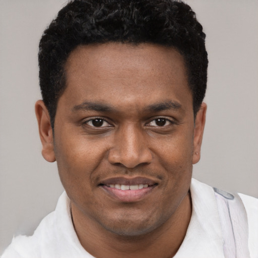 Joyful black young-adult male with short  black hair and brown eyes
