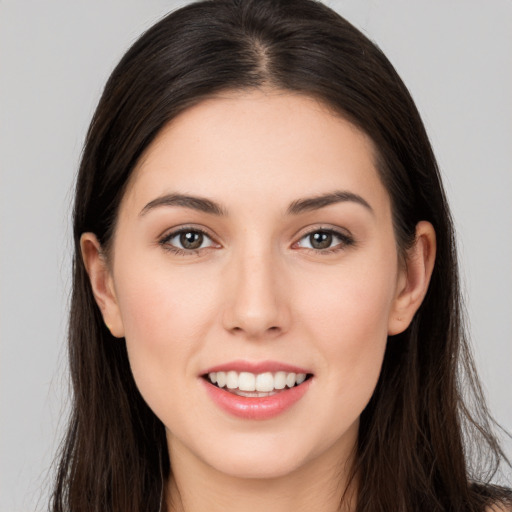 Joyful white young-adult female with long  brown hair and brown eyes