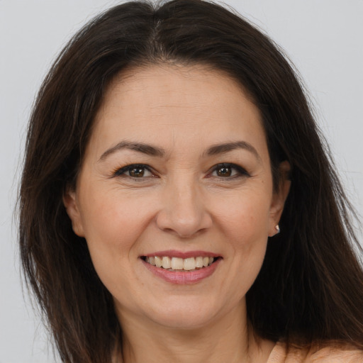 Joyful white adult female with long  brown hair and brown eyes