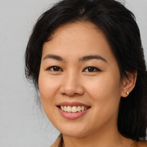 Joyful latino young-adult female with long  brown hair and brown eyes