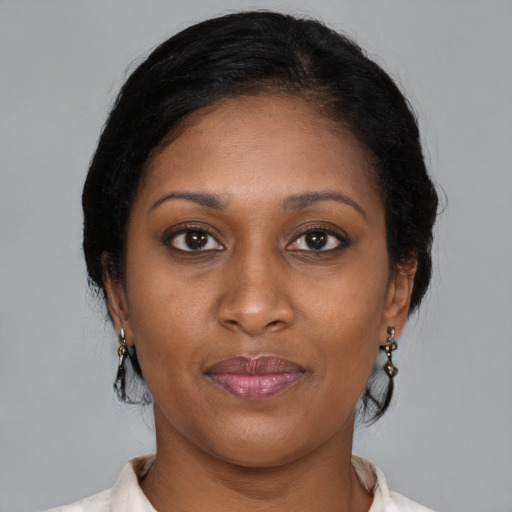Joyful black adult female with medium  brown hair and brown eyes