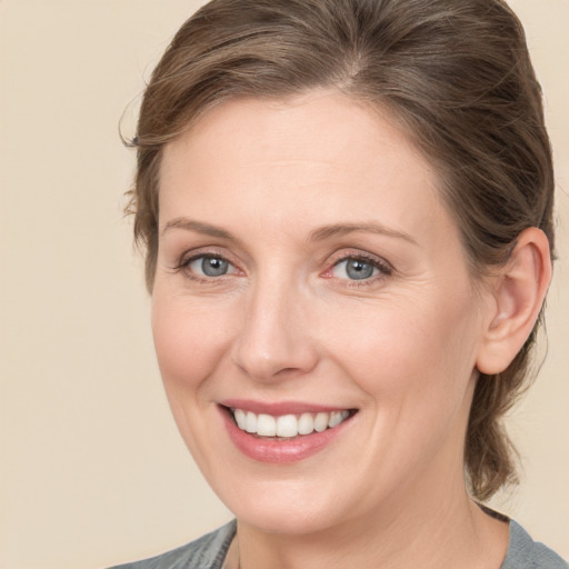 Joyful white adult female with medium  brown hair and blue eyes