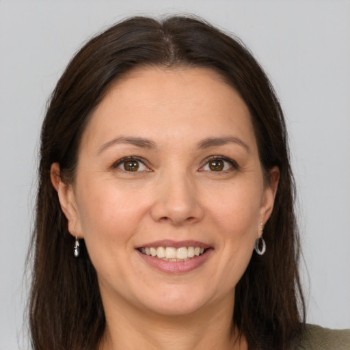 Joyful white adult female with long  brown hair and brown eyes