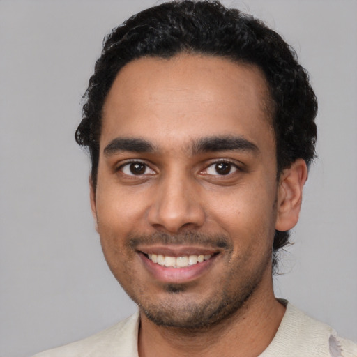 Joyful latino young-adult male with short  black hair and brown eyes