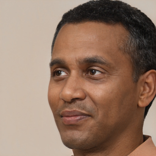 Joyful black adult male with short  black hair and brown eyes