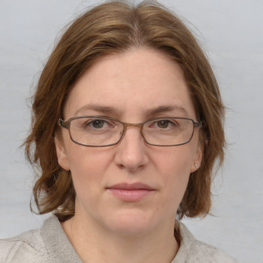 Joyful white adult female with medium  brown hair and blue eyes